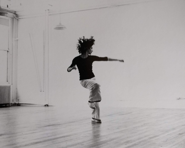 American contemporary dancer practicing a poised movement in a studio